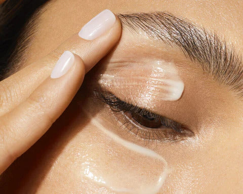 women applying eye cream to her eyelid
