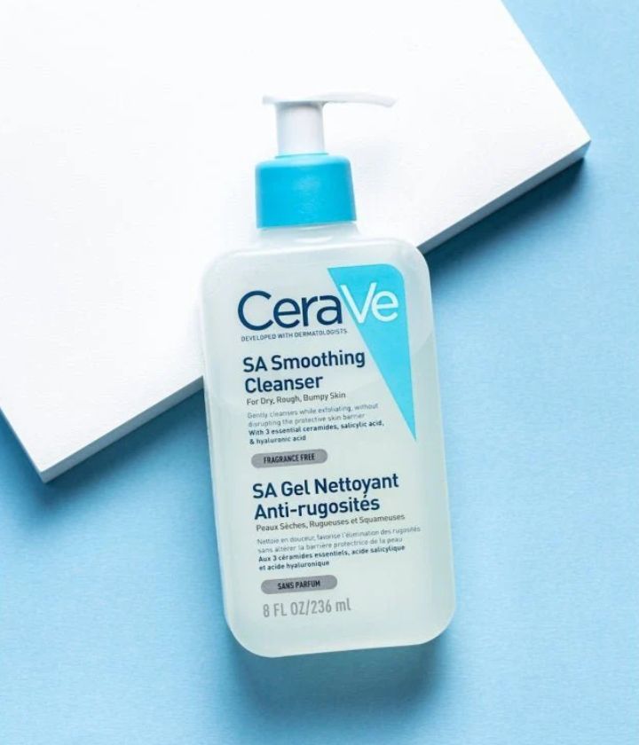 bottle of cerave SA  against a blue and white background 