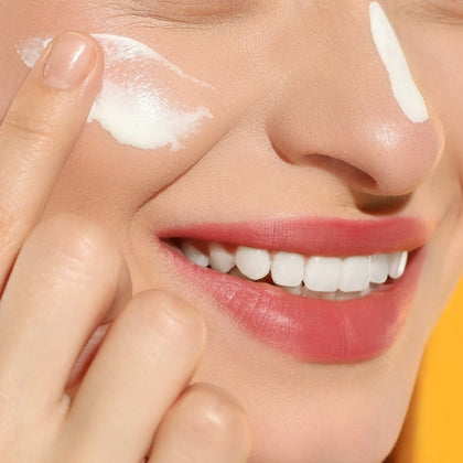 women applying spf with moisturiser to her face 