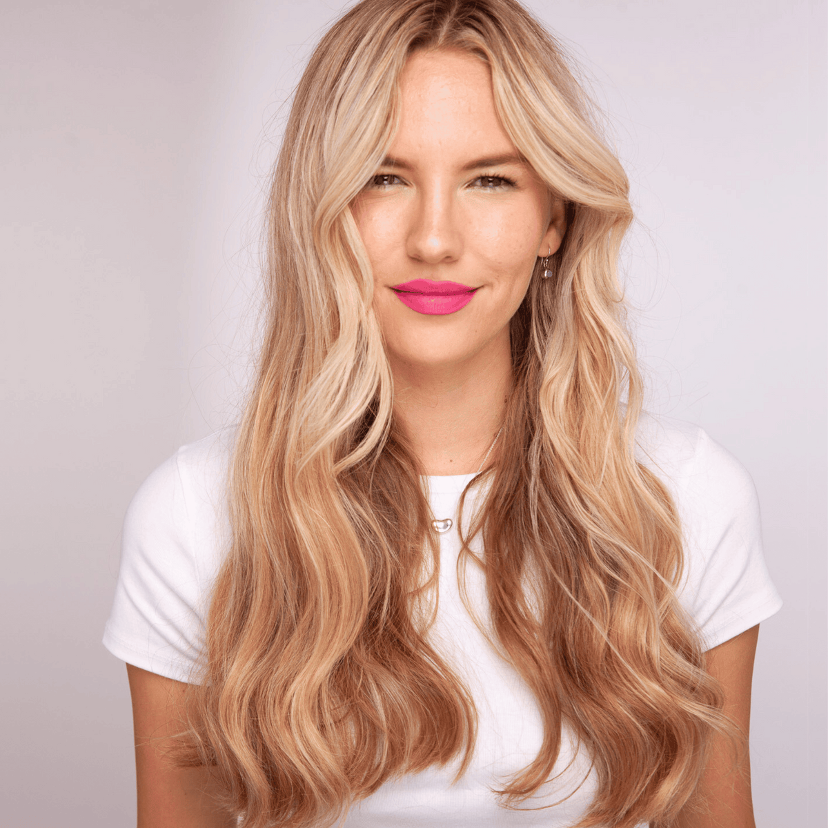 women with blonde hair who has used straighteners to put a loose wave in her hair 