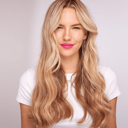 women with blonde hair who has used straighteners to put a loose wave in her hair 