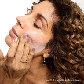 women applying serum to her face 